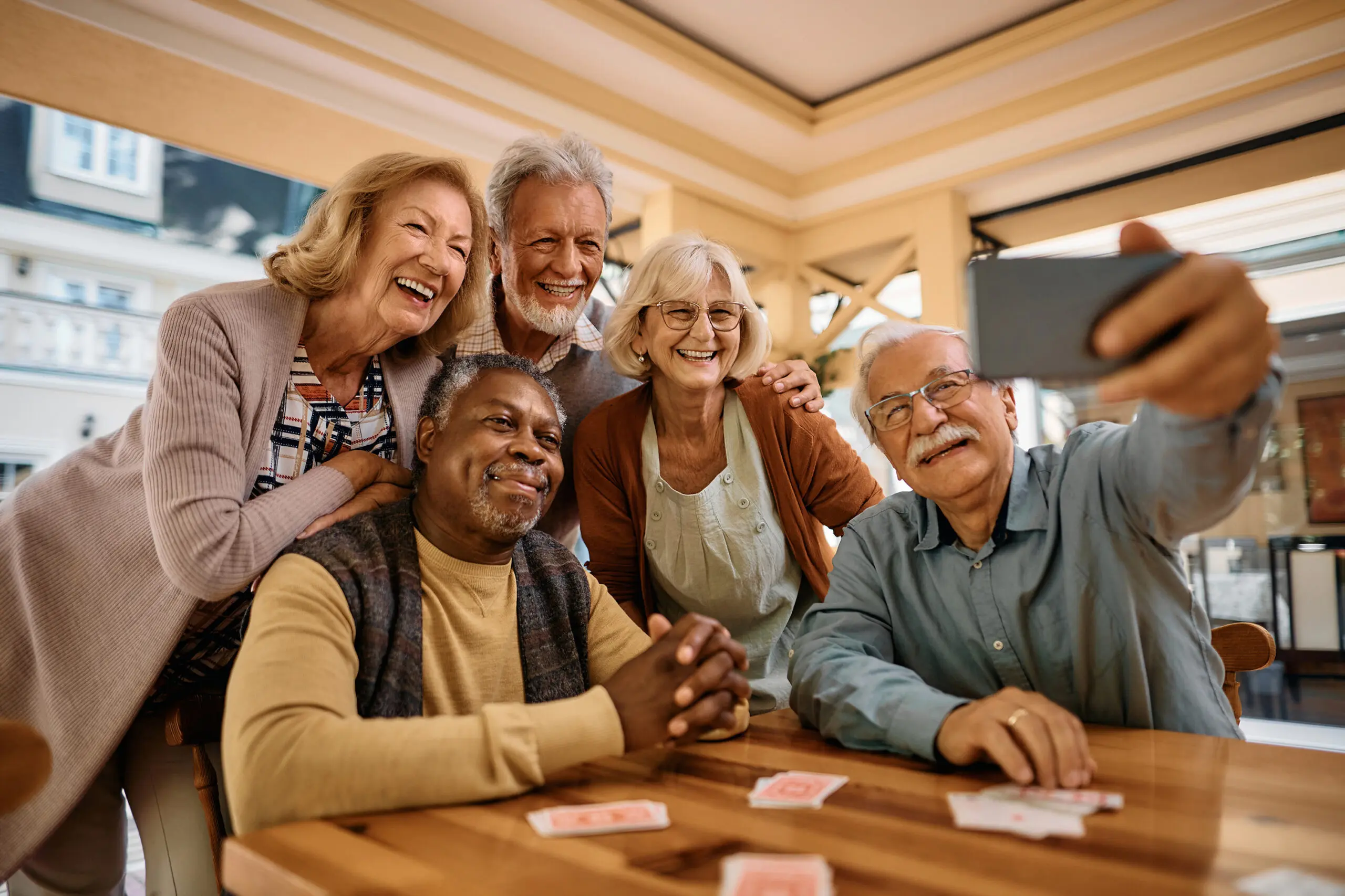 Cheerful senior have fun while taking selfie at retirement community.