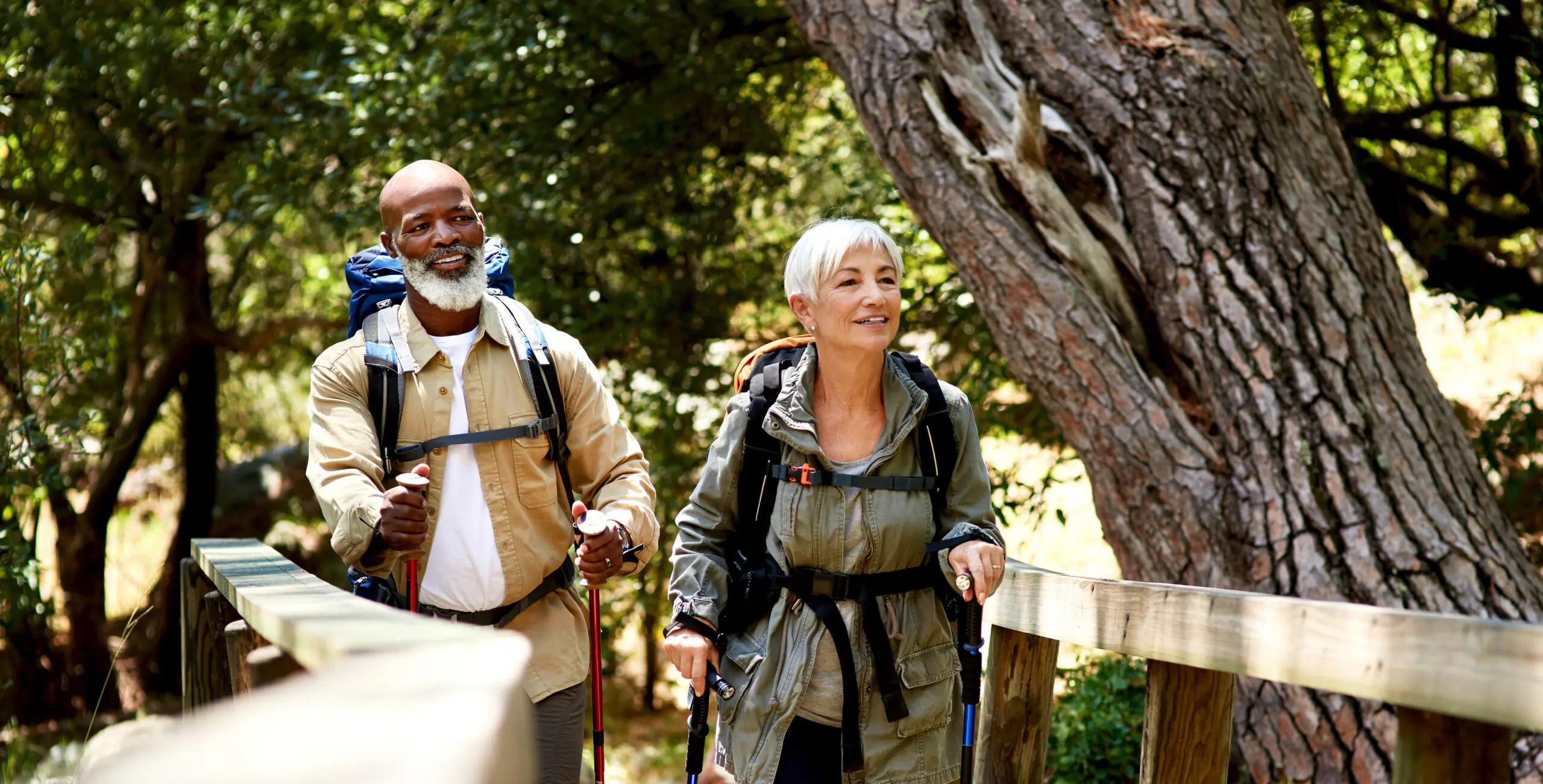 Smiling couple hikes over a bridge